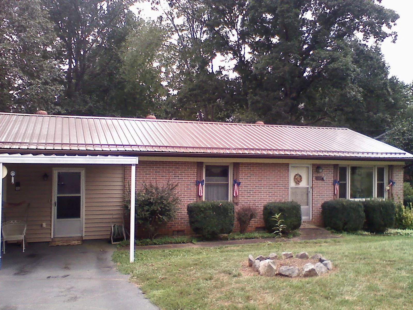 Bronze metal roof and carport on a brick ranch home — Roof Repair work by our crew in Ryegate